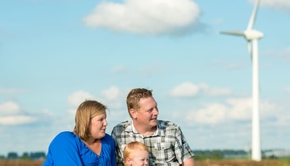 Familie am Deich mit Windanlage
